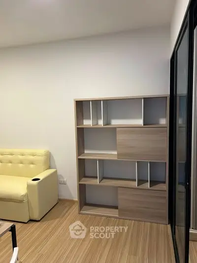 Modern living room with stylish shelving and cozy yellow sofa, perfect for urban living.