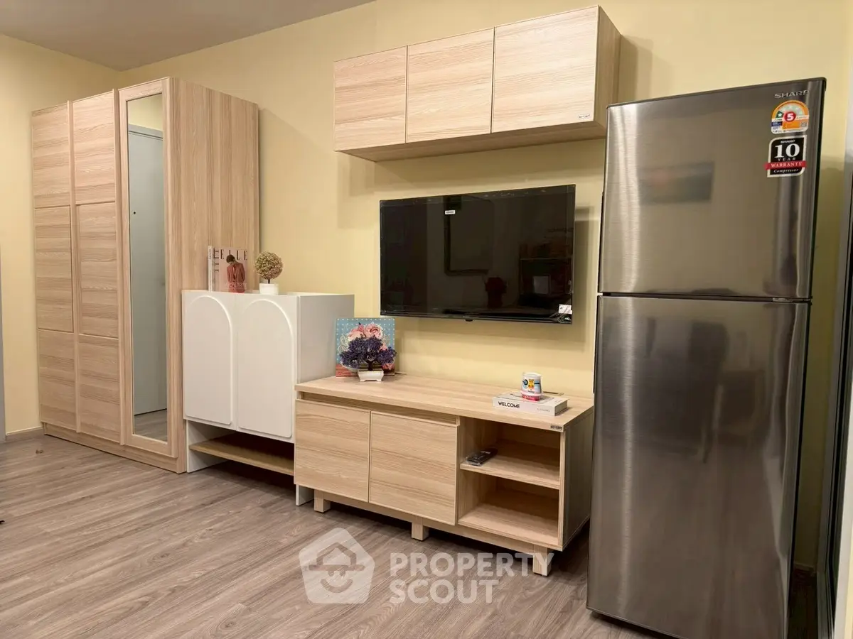 Modern living room with sleek wooden furniture and stainless steel fridge