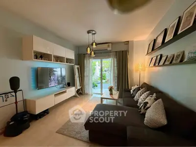 Spacious living room with modern decor and garden view, featuring cozy seating and stylish lighting.