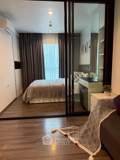 Modern bedroom with glass sliding doors and elegant decor in a stylish apartment.