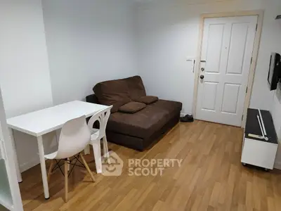 Cozy living room with brown sofa and dining table, perfect for small apartments.