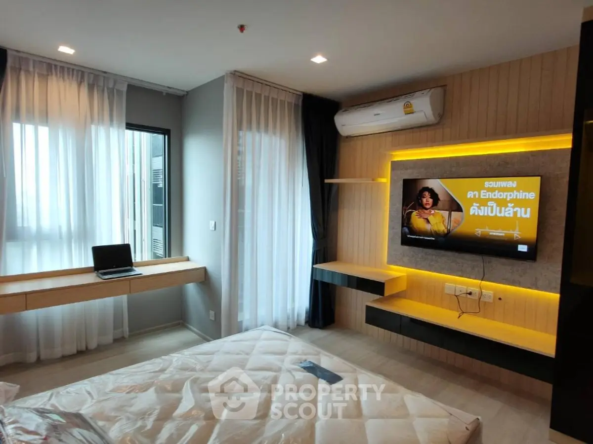 Modern bedroom with stylish decor, featuring a wall-mounted TV and air conditioning, perfect for comfort and relaxation.