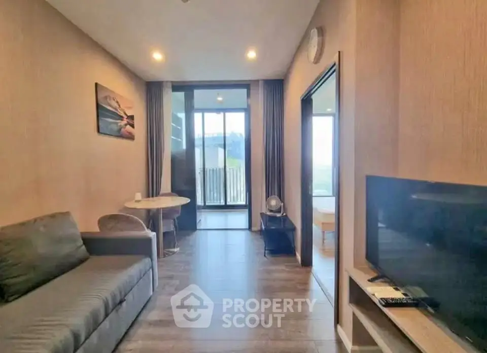 Modern living room with sleek furniture and large windows offering natural light.