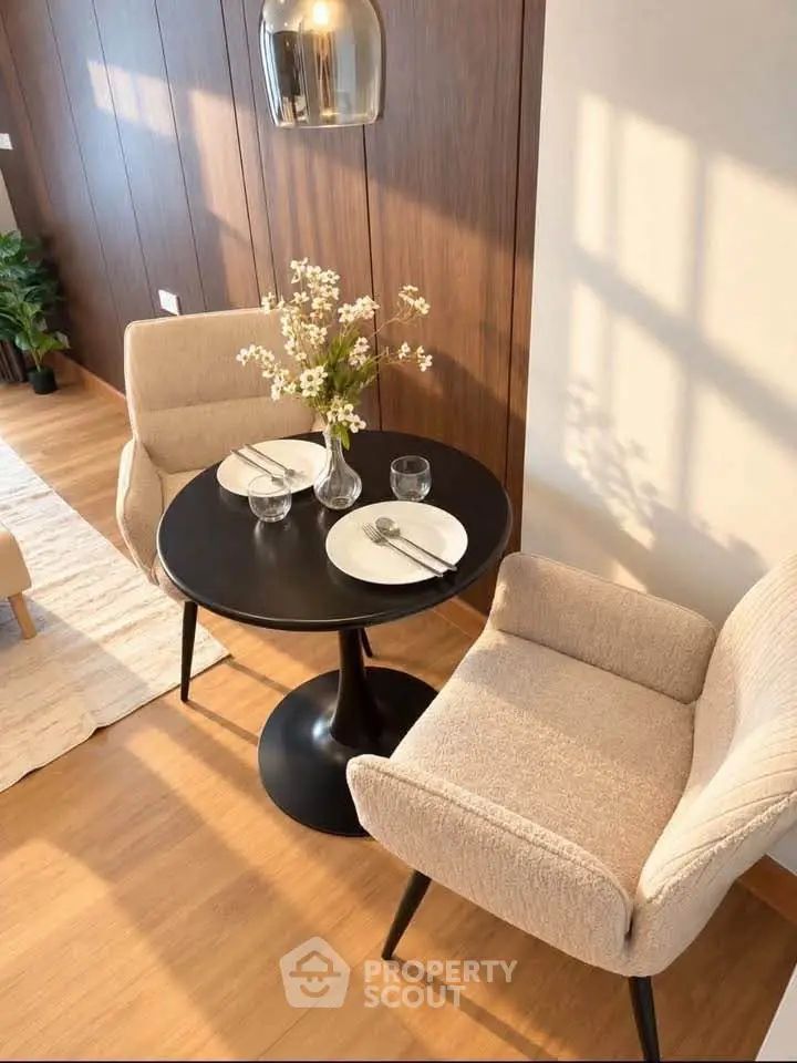Cozy dining nook with elegant chairs and a round table set for two, perfect for intimate meals.