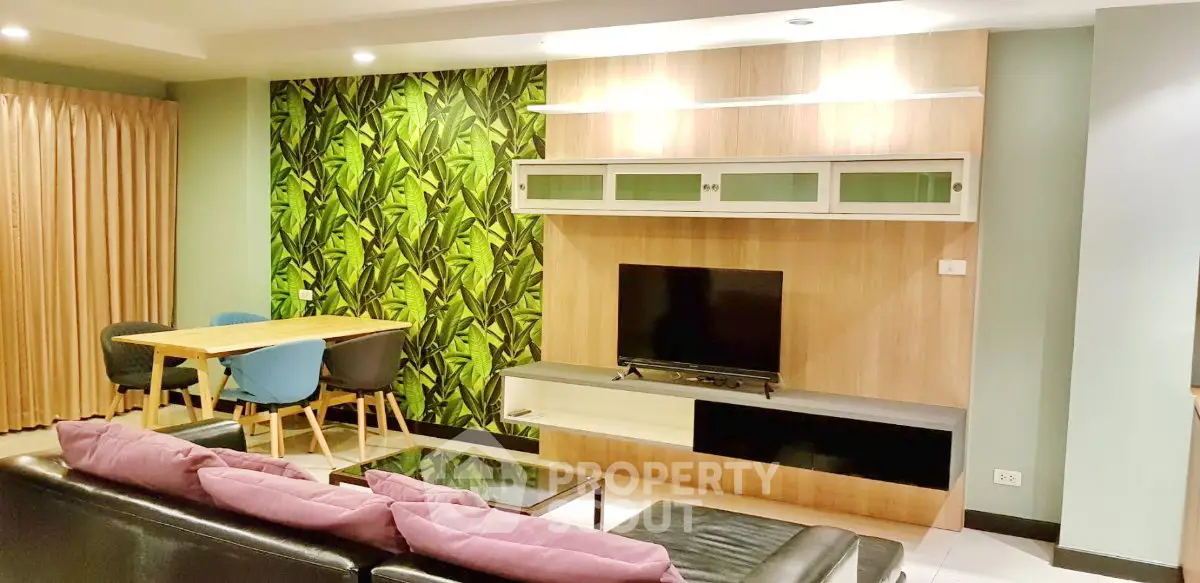 Stylish living room with modern decor, vibrant green accent wall, and cozy seating area.