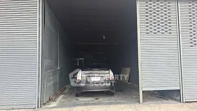 Spacious garage with a car parked inside, featuring large sliding doors.