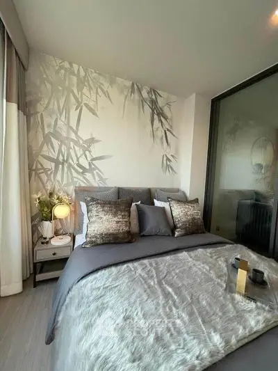 Luxurious bedroom with elegant decor and plush bedding in modern apartment.
