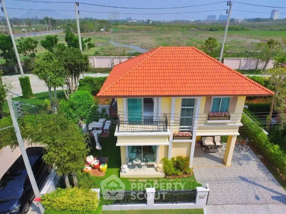 Charming two-story house with red tile roof and lush garden in serene neighborhood.