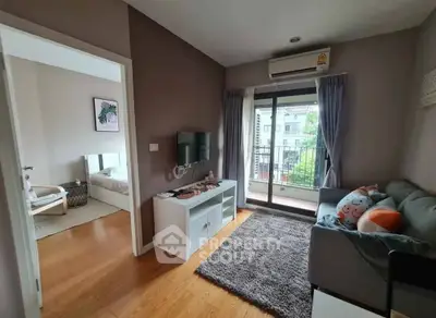 Modern living room with balcony access and cozy decor in a stylish apartment.