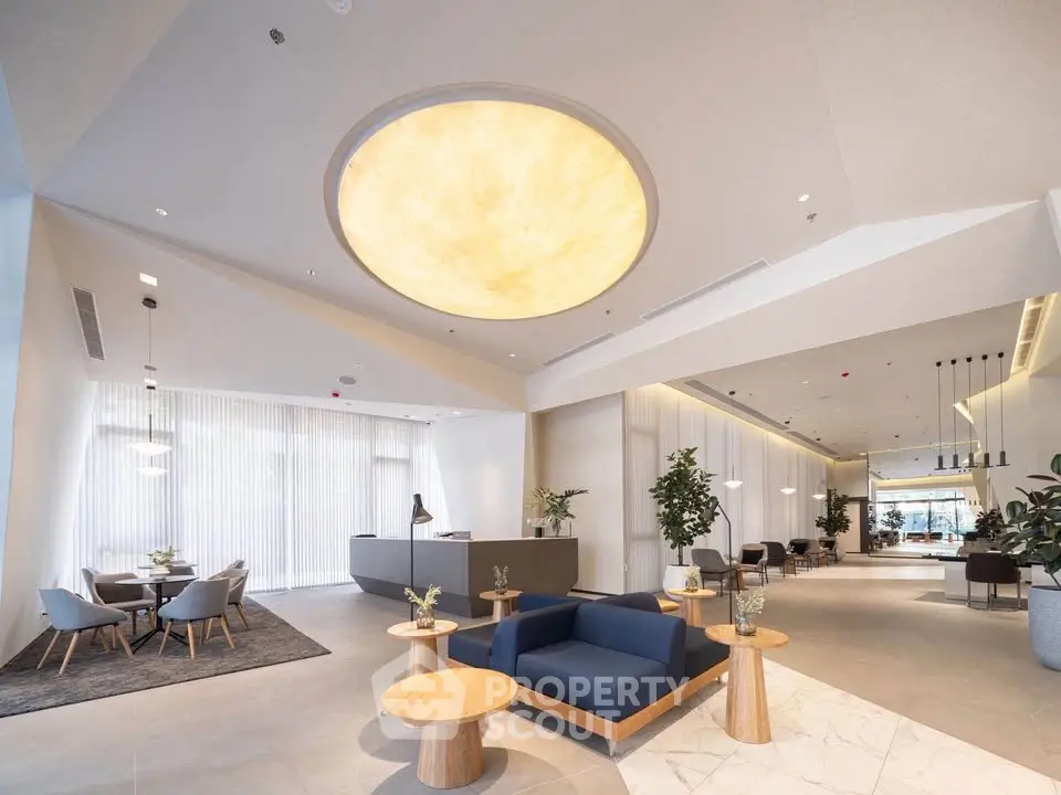 Luxurious modern lobby with elegant seating and stunning ceiling design in upscale building.