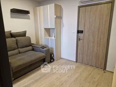 Cozy living room with modern sofa and wooden flooring, perfect for relaxation.