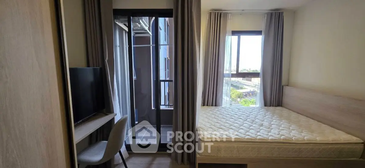 Modern bedroom with balcony access and natural light in urban apartment