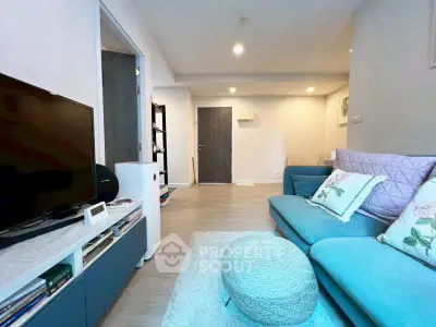 Modern living room with stylish blue sofa and TV, perfect for relaxation.