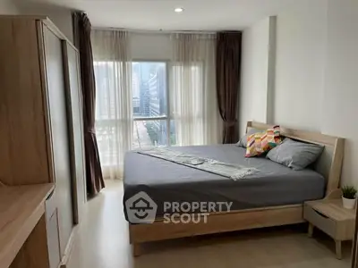 Modern bedroom with city view, featuring a cozy bed and stylish decor in a high-rise apartment.