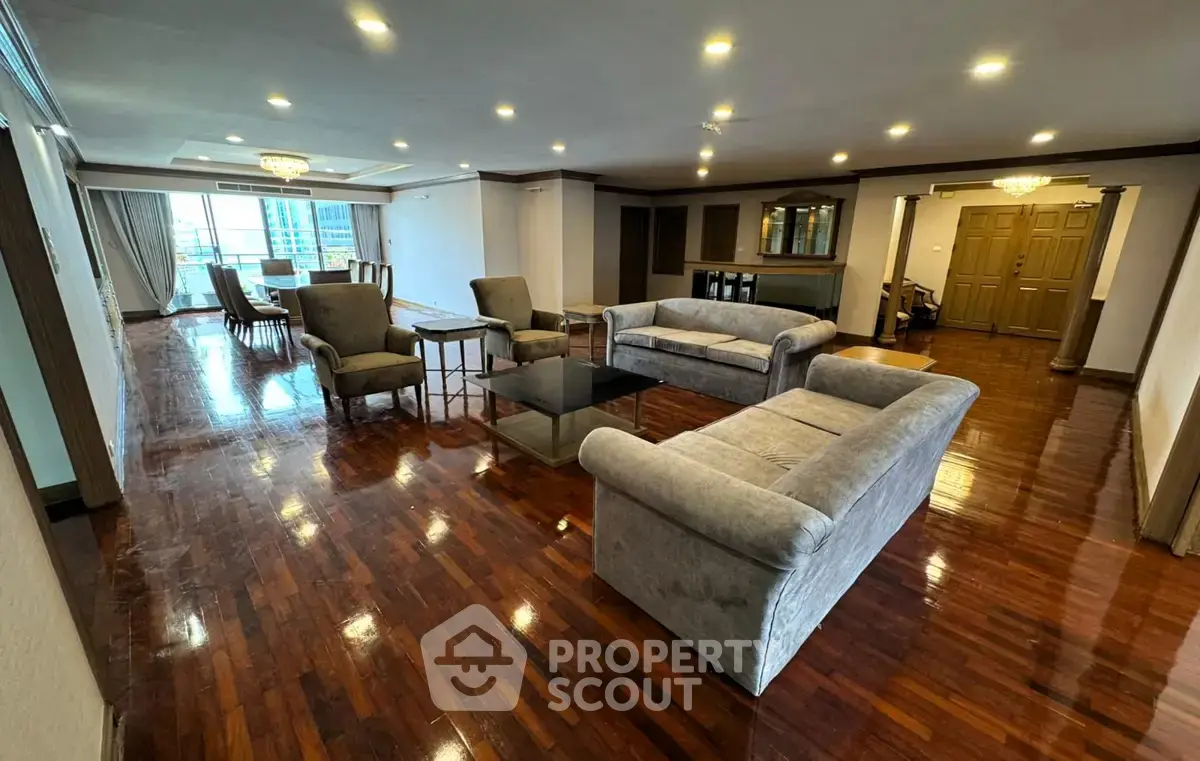 Spacious living room with elegant furniture and polished wooden floors in a luxury apartment.