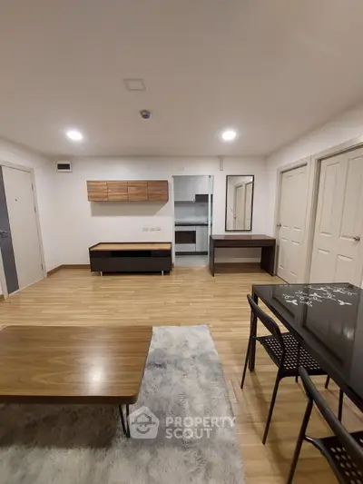 Modern living room with wooden flooring and sleek furniture in a stylish apartment.