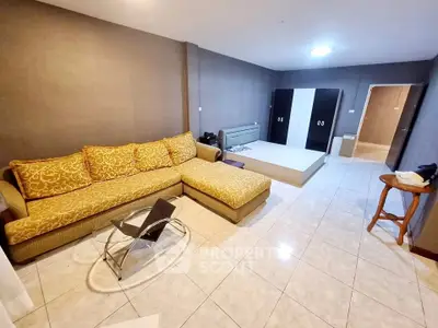 Spacious living room with modern sofa and sleek tile flooring in a stylish apartment.