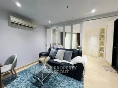 Modern living room with sleek design, featuring a cozy sofa, glass coffee table, and stylish decor.