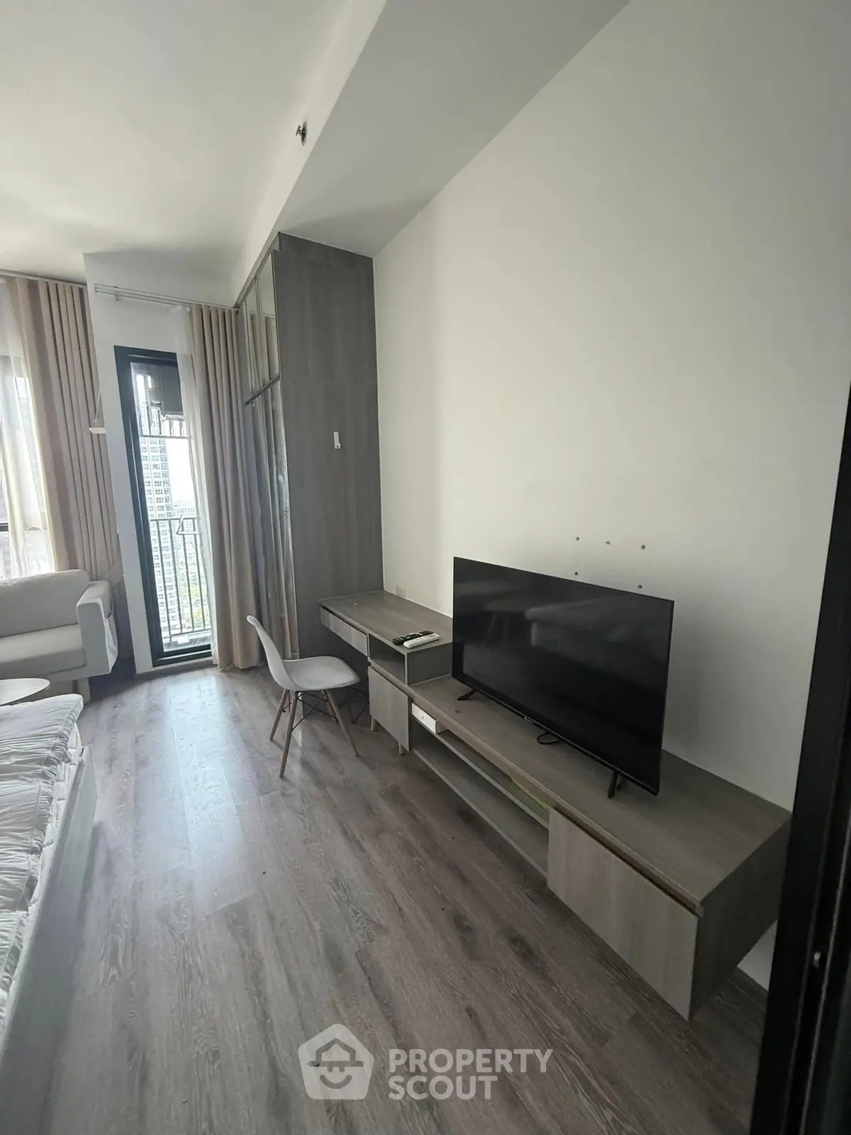 Modern living room with sleek TV setup and balcony view