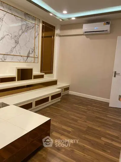 Modern living room with elegant wood flooring and built-in storage