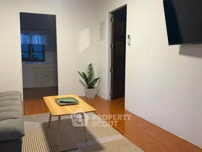 Cozy living room with modern decor and wall-mounted TV, perfect for relaxation.