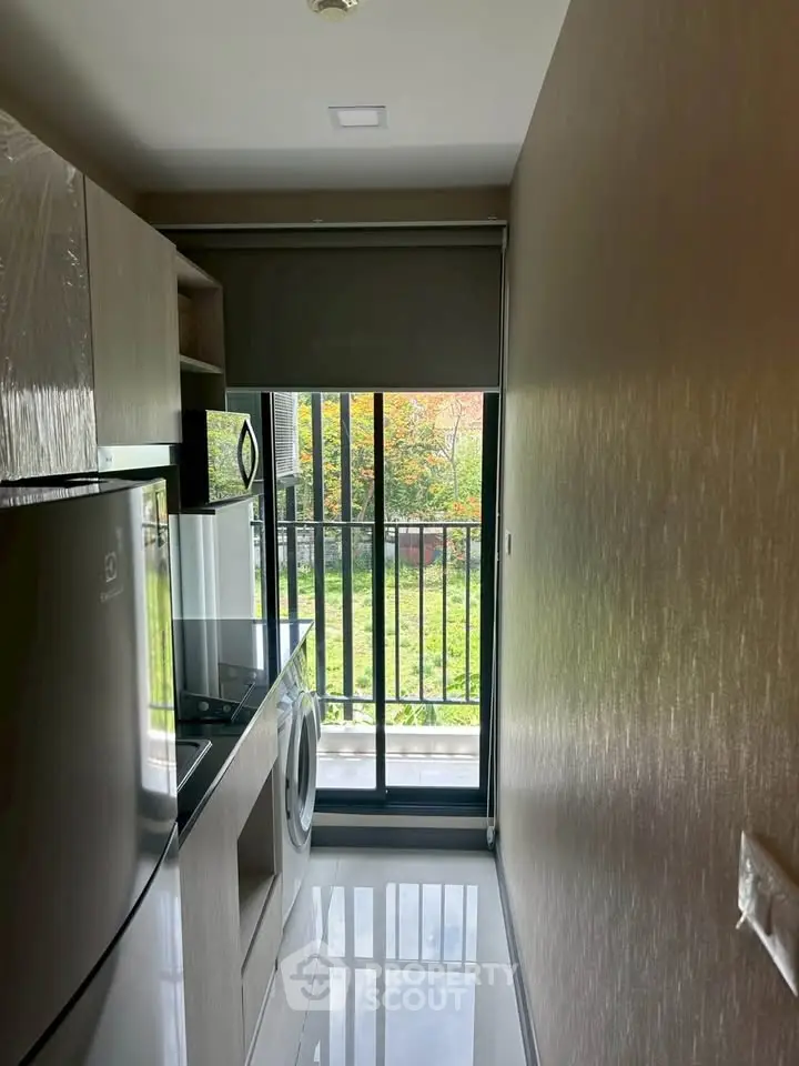 Modern kitchen with sleek appliances and balcony view, perfect for urban living.