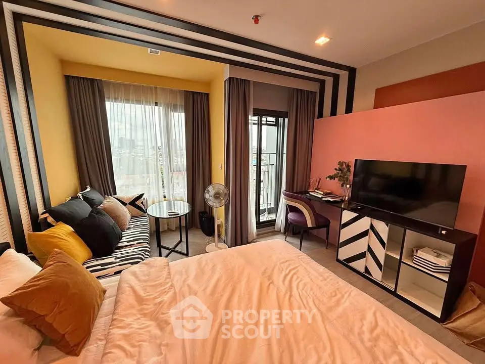 Stylish modern bedroom with balcony and vibrant decor in a high-rise apartment.