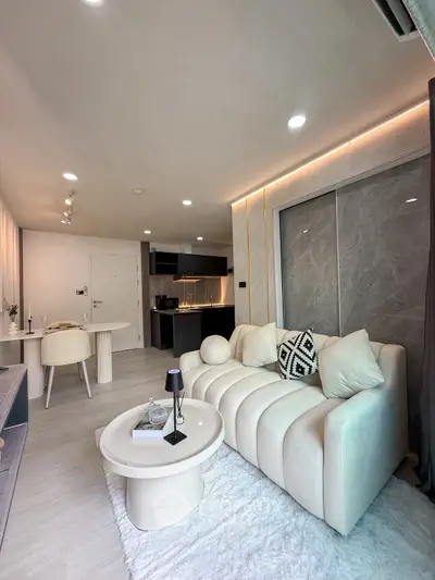 Modern living room with stylish decor and open kitchen layout in a contemporary apartment.