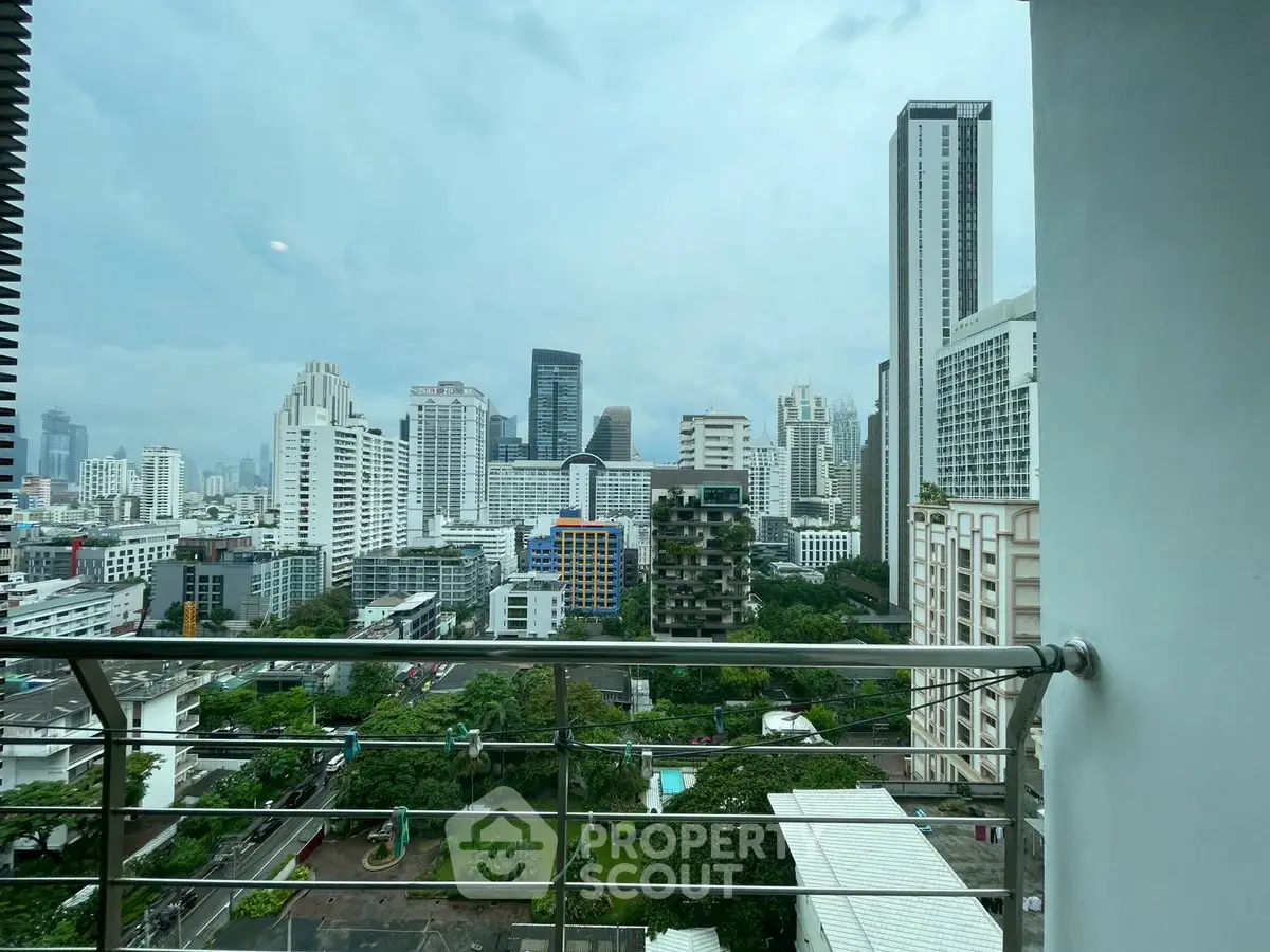 Stunning cityscape view from a high-rise balcony showcasing urban skyline and lush greenery.