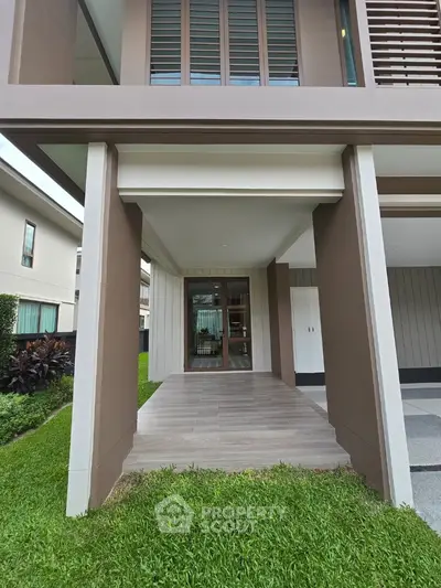 Modern house entrance with sleek design and lush greenery