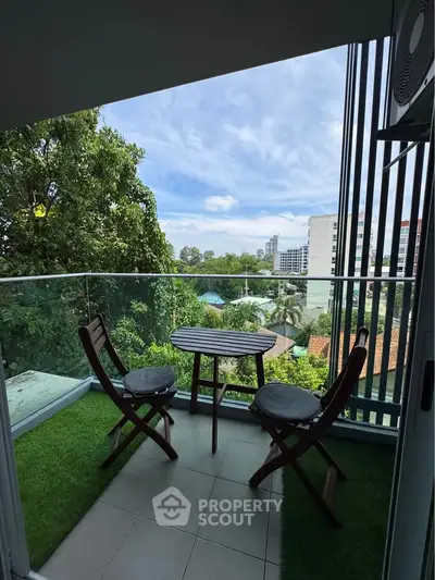Charming balcony with lush greenery view, perfect for relaxation and outdoor dining.