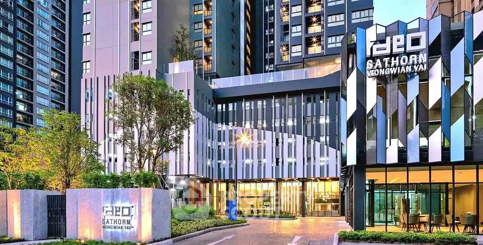 Modern high-rise building exterior with sleek design and lush landscaping at sunset.
