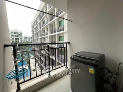 Modern apartment balcony with washing machine and pool view
