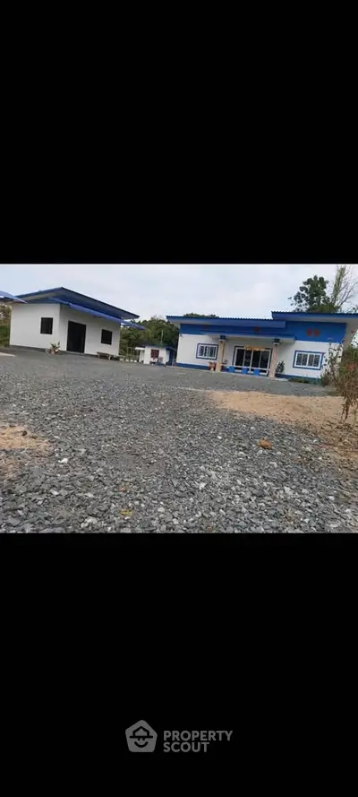 Charming countryside property with spacious yard and modern blue-roofed house.
