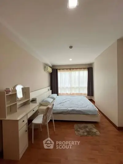 Spacious bedroom with natural light and modern furnishings in a stylish apartment.