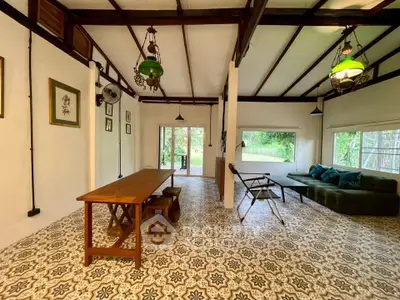 Charming living room with vintage decor and garden view, featuring patterned tile flooring and cozy seating.
