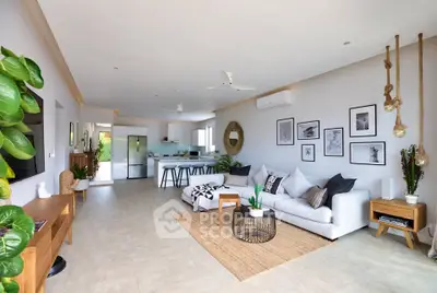Spacious modern living room with open kitchen, stylish decor, and natural light.