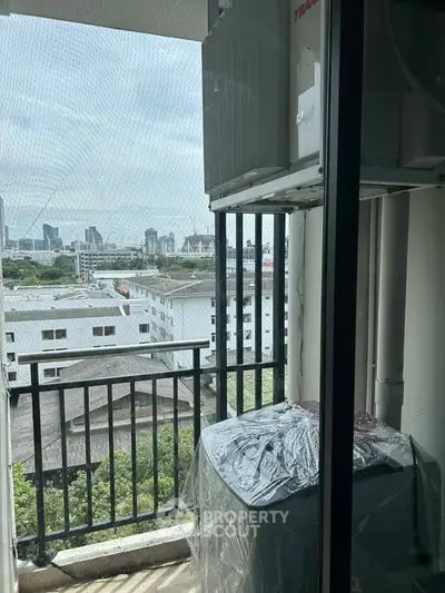 High-rise balcony with city view and outdoor air conditioning unit.