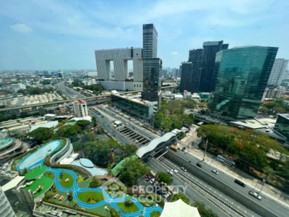 Stunning cityscape view from high-rise building with modern architecture and lush greenery.