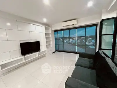 Modern living room with sleek design, large windows, and city view.