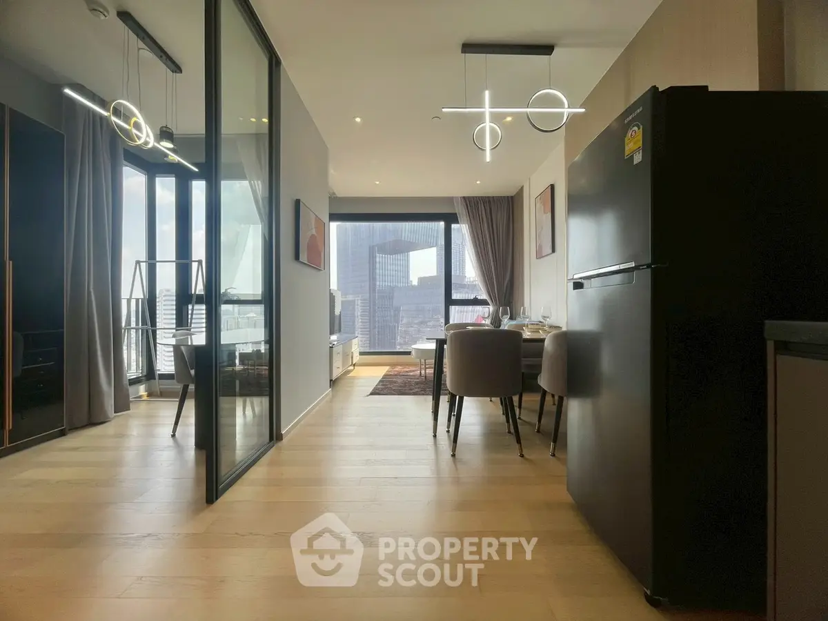 Modern open-plan living and dining area with city view and stylish lighting fixtures.