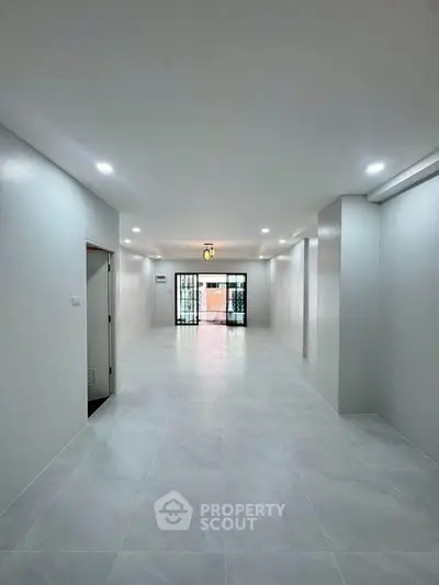 Spacious open-plan living area with modern lighting and large windows for natural light.