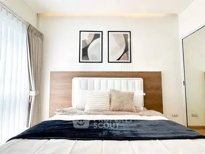 Modern bedroom with stylish decor and natural light, featuring a cozy bed and elegant artwork.