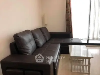 Modern living room with sleek black leather sofa and glass coffee table, perfect for stylish urban living.
