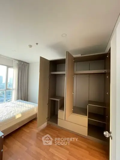 Spacious bedroom with large wardrobe and city view, perfect for modern living.