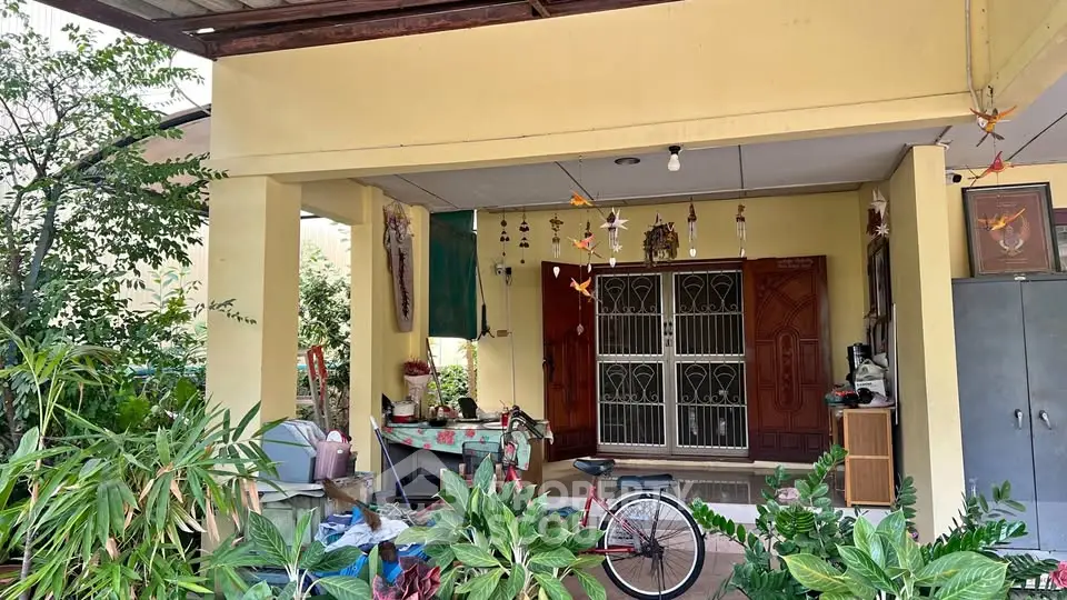 Charming residential entrance with lush greenery and cozy decor