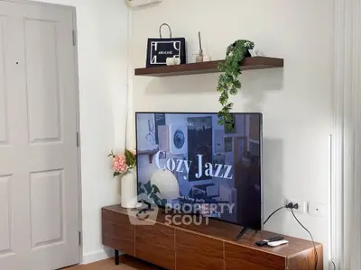 Stylish living room with modern TV setup and elegant decor on wooden shelves.