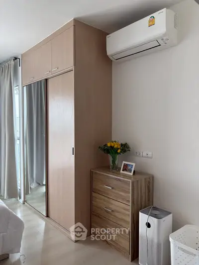 Modern bedroom with sleek wardrobe and air conditioning, perfect for comfortable living.