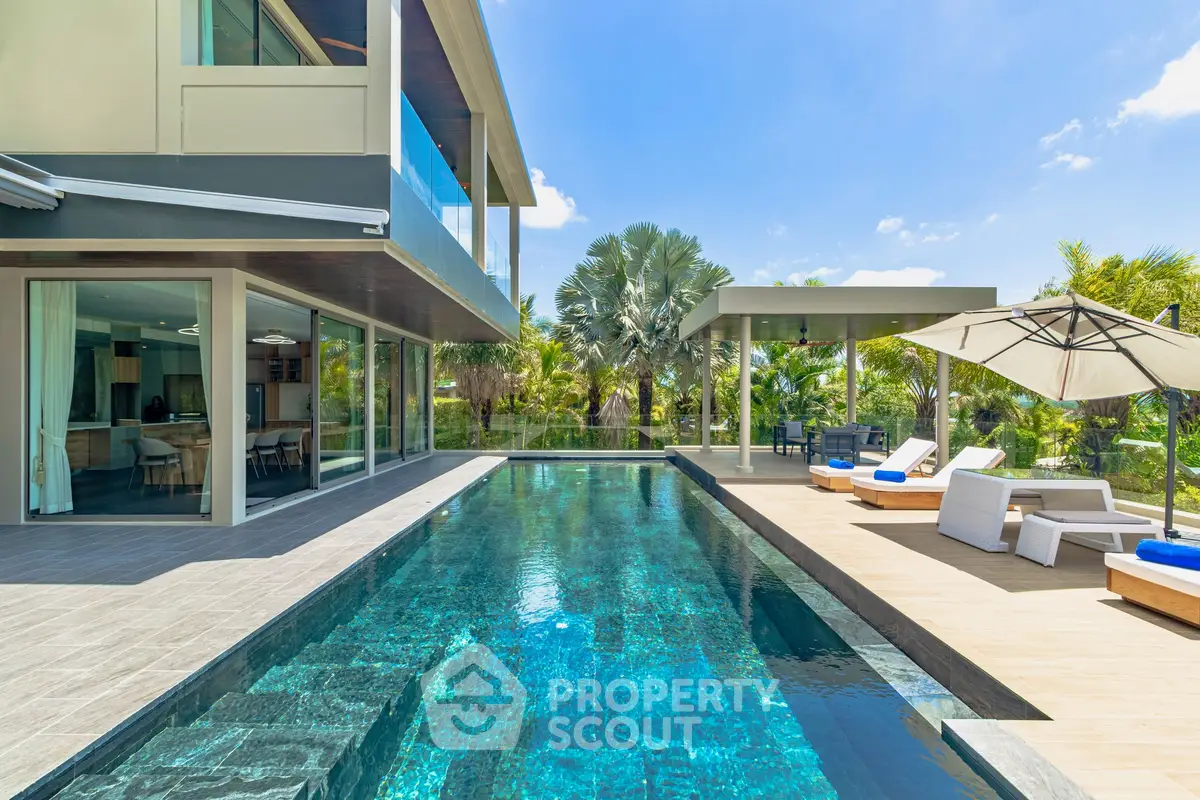 Luxurious modern villa with stunning pool and spacious outdoor lounge area.