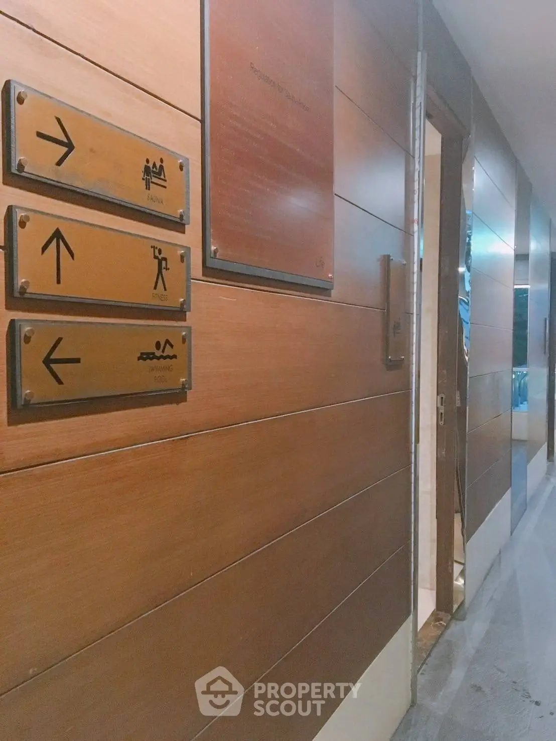 Modern hallway with directional signs to amenities like pool and gym